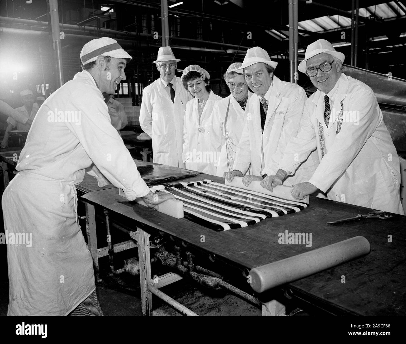 Cravens Candyland Süßwaren Unternehmen in York, North Yorkshire, Großbritannien, Großbritannien 1985 - ein Arbeiter, Kandis erhält Hilfe von Amtsträger in 1985 Stockfoto