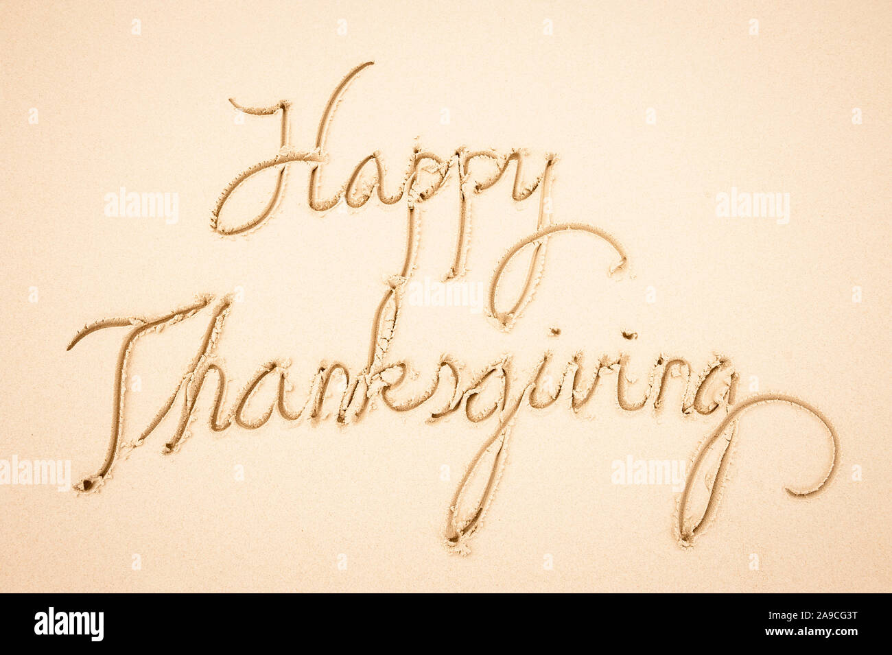 Happy Thanksgiving Nachricht handschriftlich in einfache Schreibschrift script auf glatten Sandstrand Stockfoto