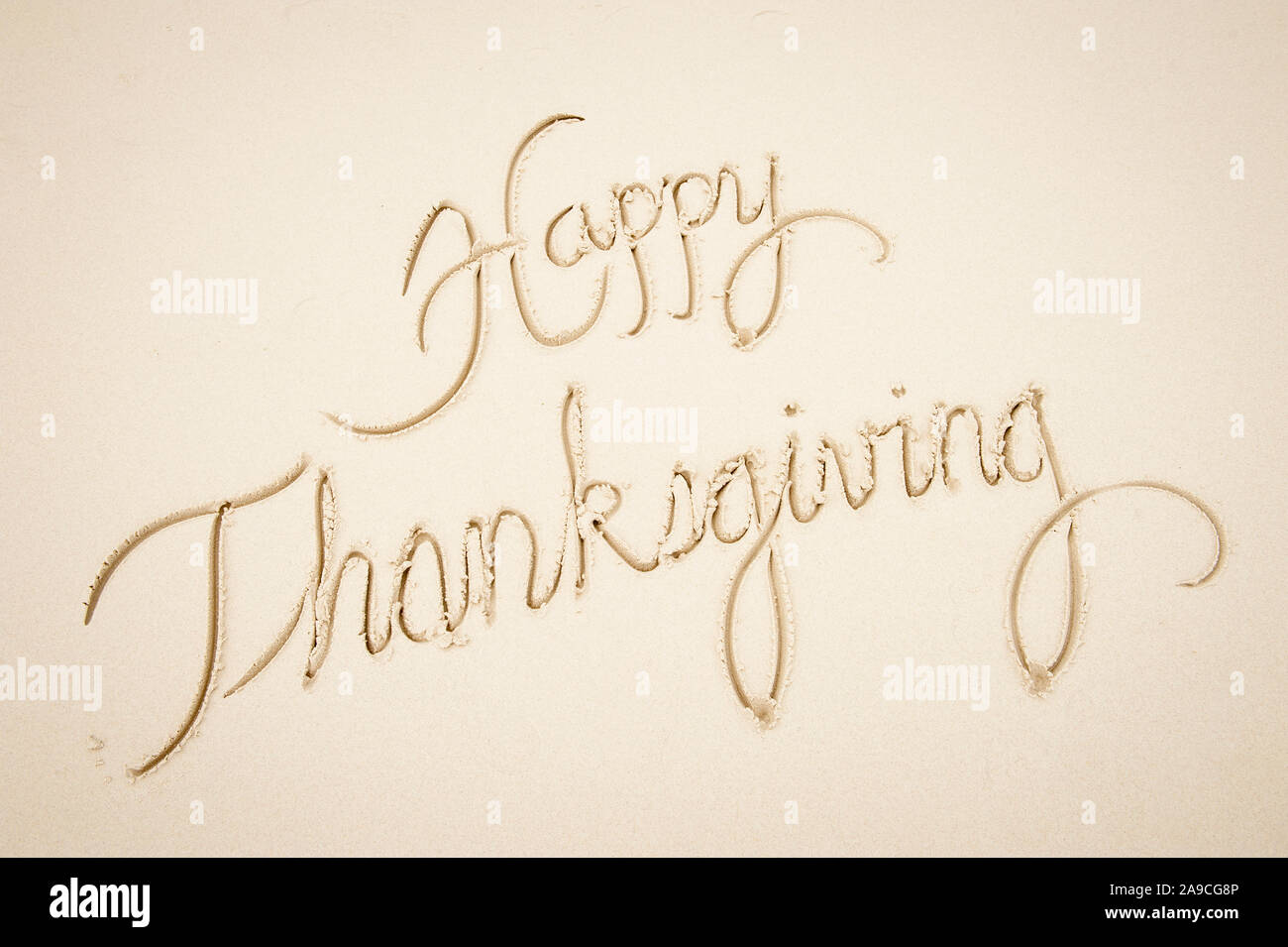 Happy Thanksgiving Nachricht handschriftlich in einfache Schreibschrift script auf glatten Sandstrand Stockfoto