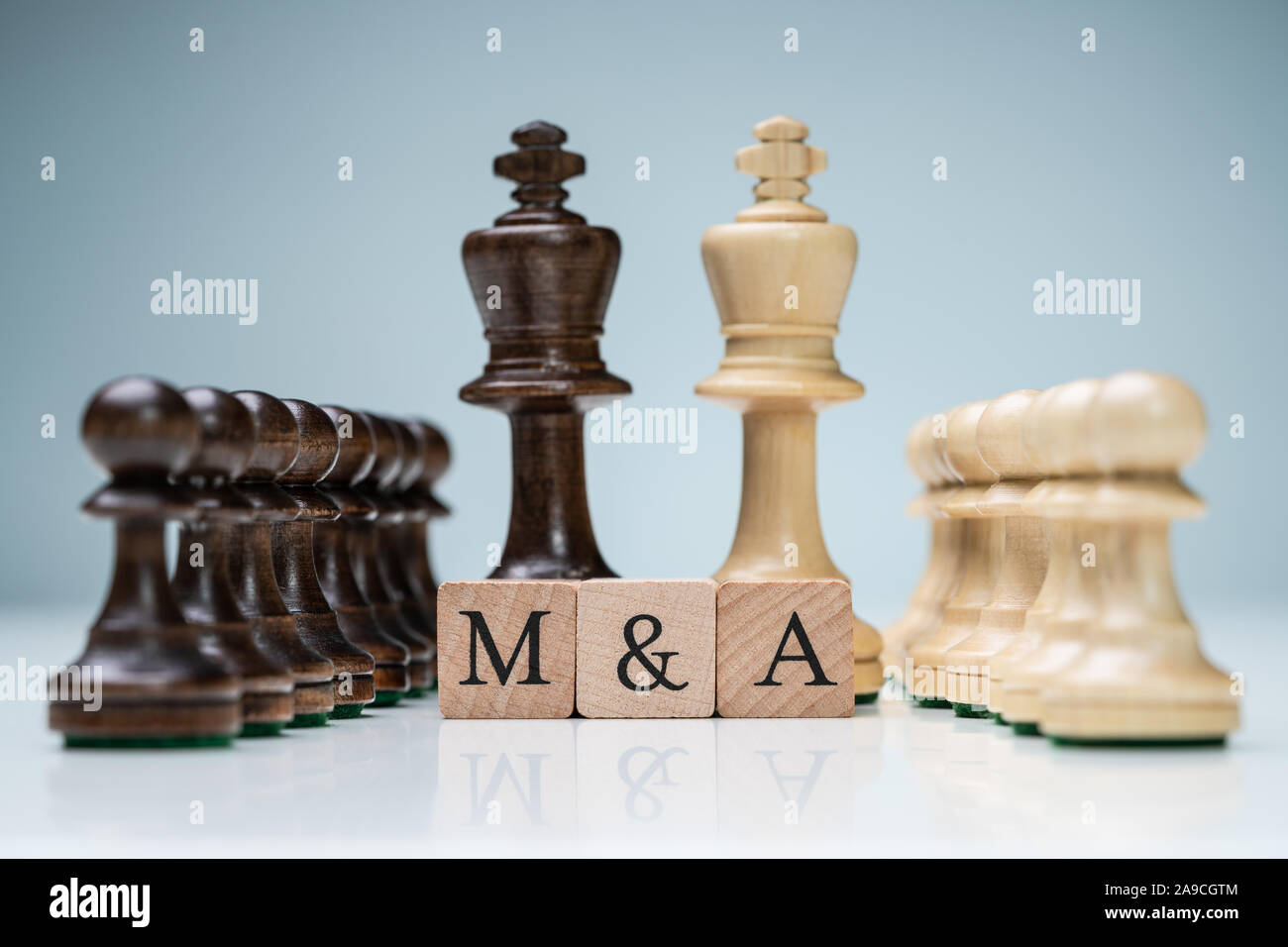 König und Königin Holz- Schachfiguren mit dem Buchstaben M und einem hölzernen Blöcke Stockfoto