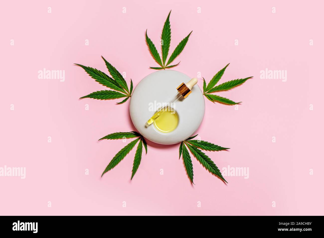 CBD cannabis Öl mit Hanf Blätter auf rosa Hintergrund. Kopieren Sie Platz. Stockfoto
