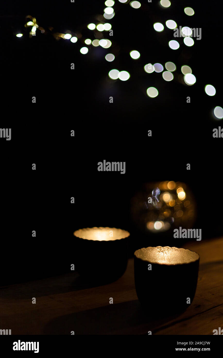 Hintergrund unscharf mit Kerzen Dekoration auf Holztisch im Dunkeln mit Lichtern Gemütlichkeit und zusammen erhalten und Parteien Stockfoto