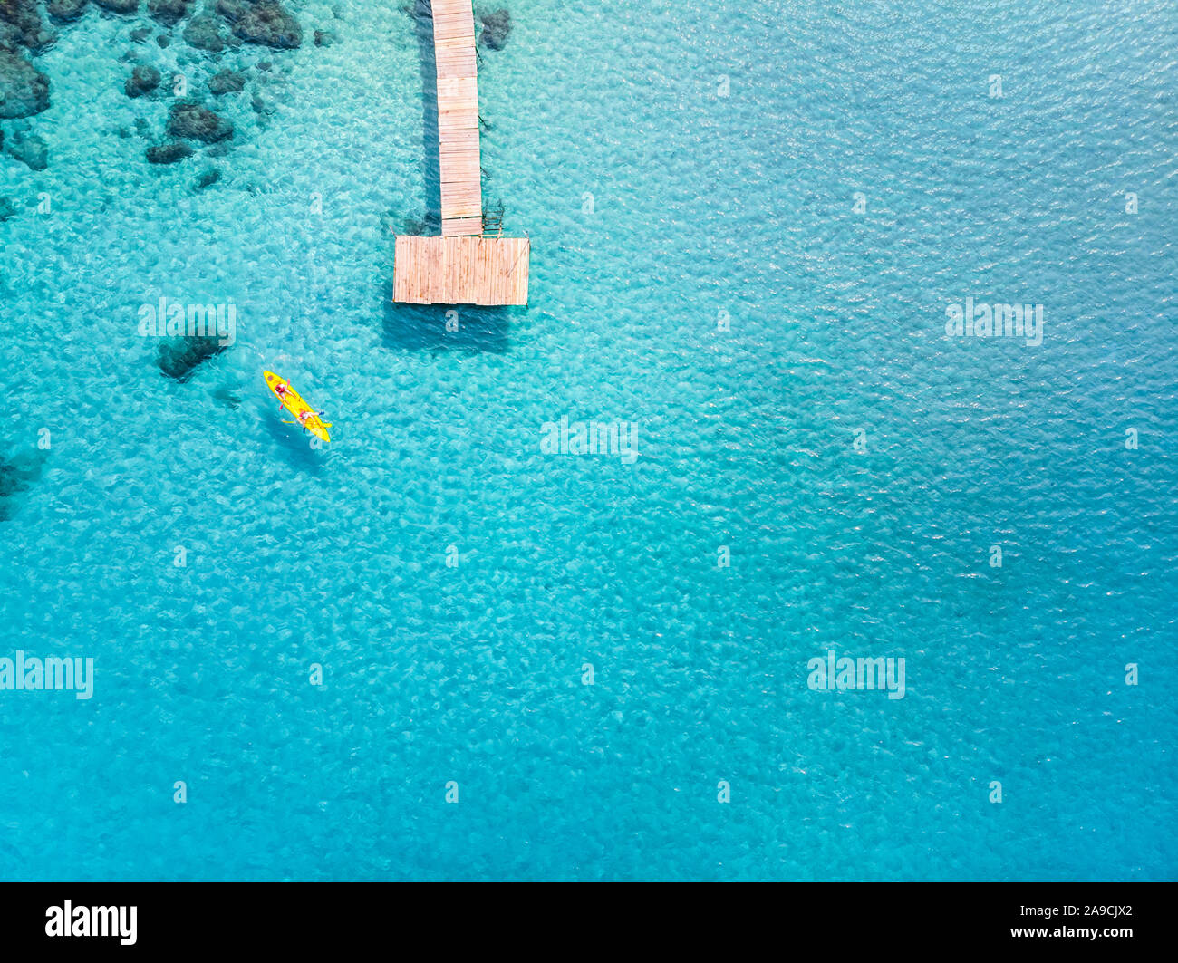 Tropical Beach von drohne am schönen Urlaub Ferien Destination mit transparenten, türkisfarbene Meer Wasser, dem Pier und den Menschen Kajak gesehen. Von oben nach unten ein Stockfoto