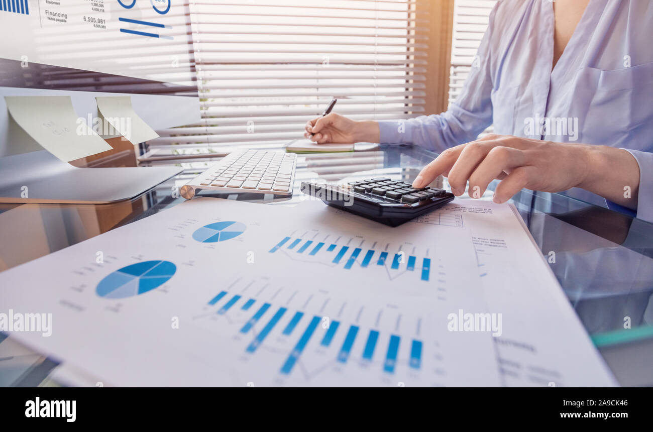 Für Personen, die mit finanziellen Bericht und Analyse der Einnahmen und Ausgaben die Daten mit dem Rechner im Büro Stockfoto
