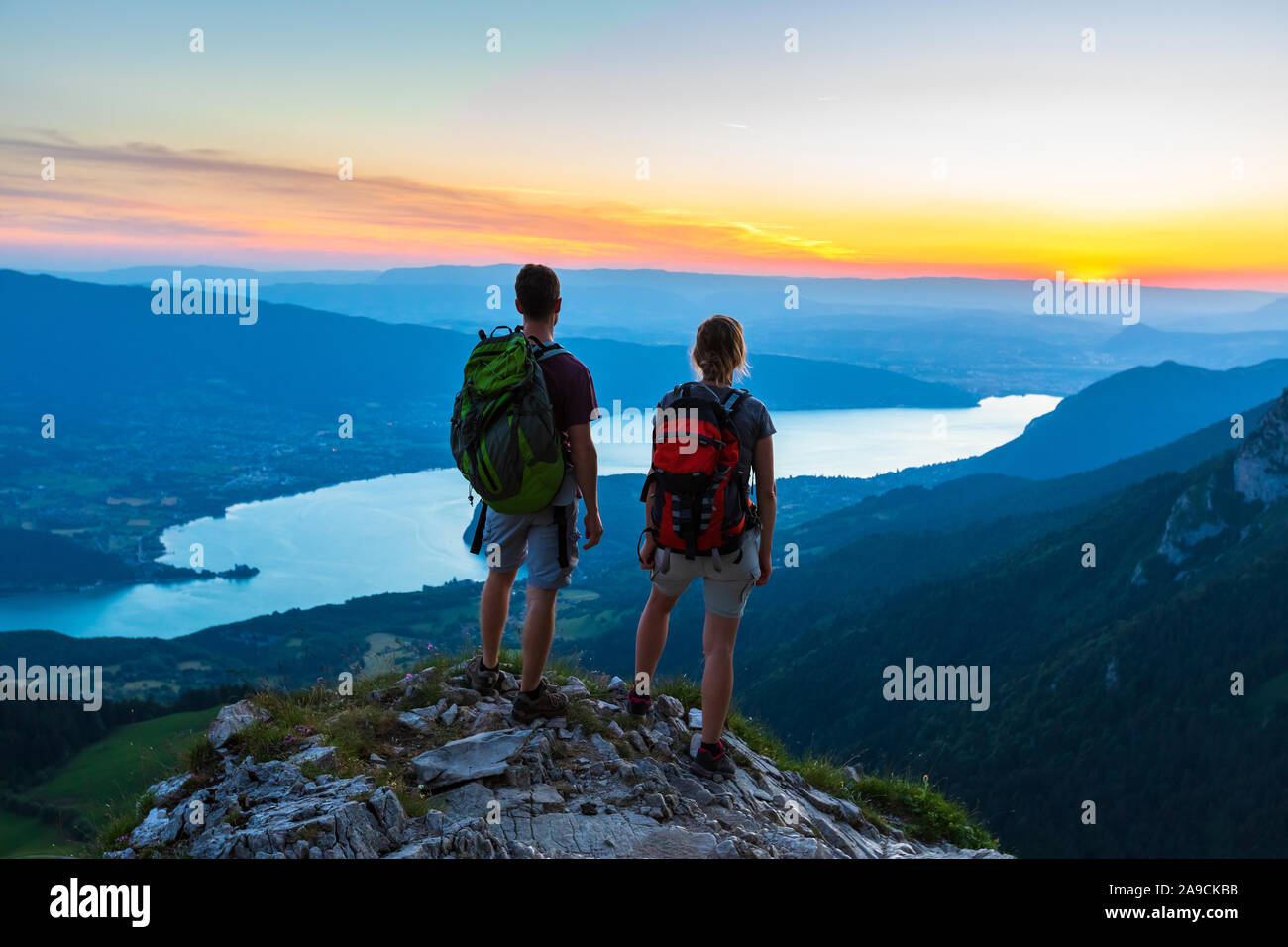 Wanderer genießen Sie malerische Aussicht auf Tal mit dem See bei Sonnenuntergang, Paar beim Außenpool im Sommer Wandern in den Bergen, aktiven Lebensstil, zwei Leute backpacking Stockfoto Wanderer genießen Sie malerische Aussicht auf Tal mit dem See bei Sonnenuntergang, Paar beim Außenpool im Sommer Wandern in den Bergen, aktiven Lebensstil, zwei Leute backpacking Stockfoto