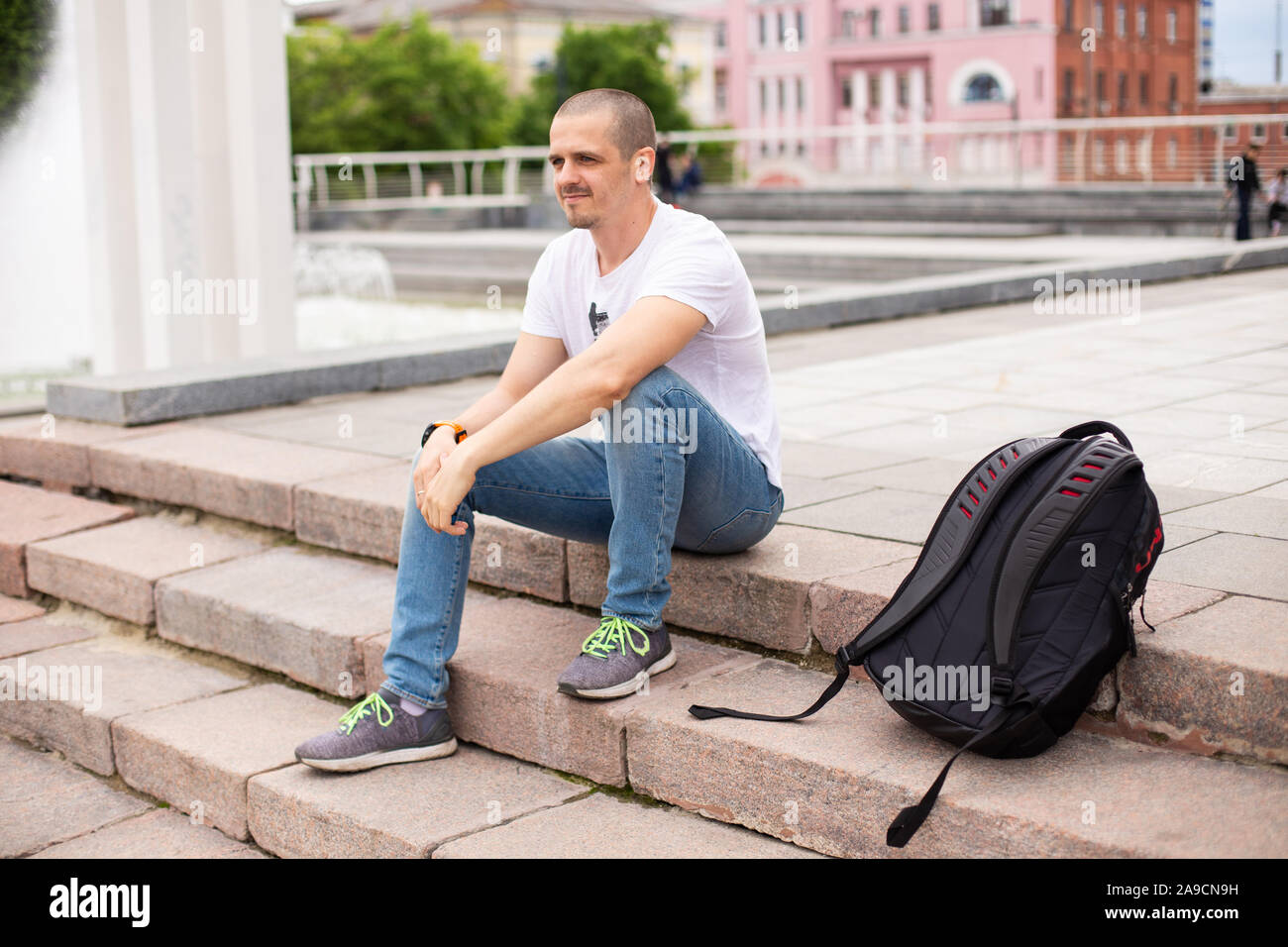 Man Reisenden sitzen auf Treppen und entspannen im städtischen Park Stockfoto