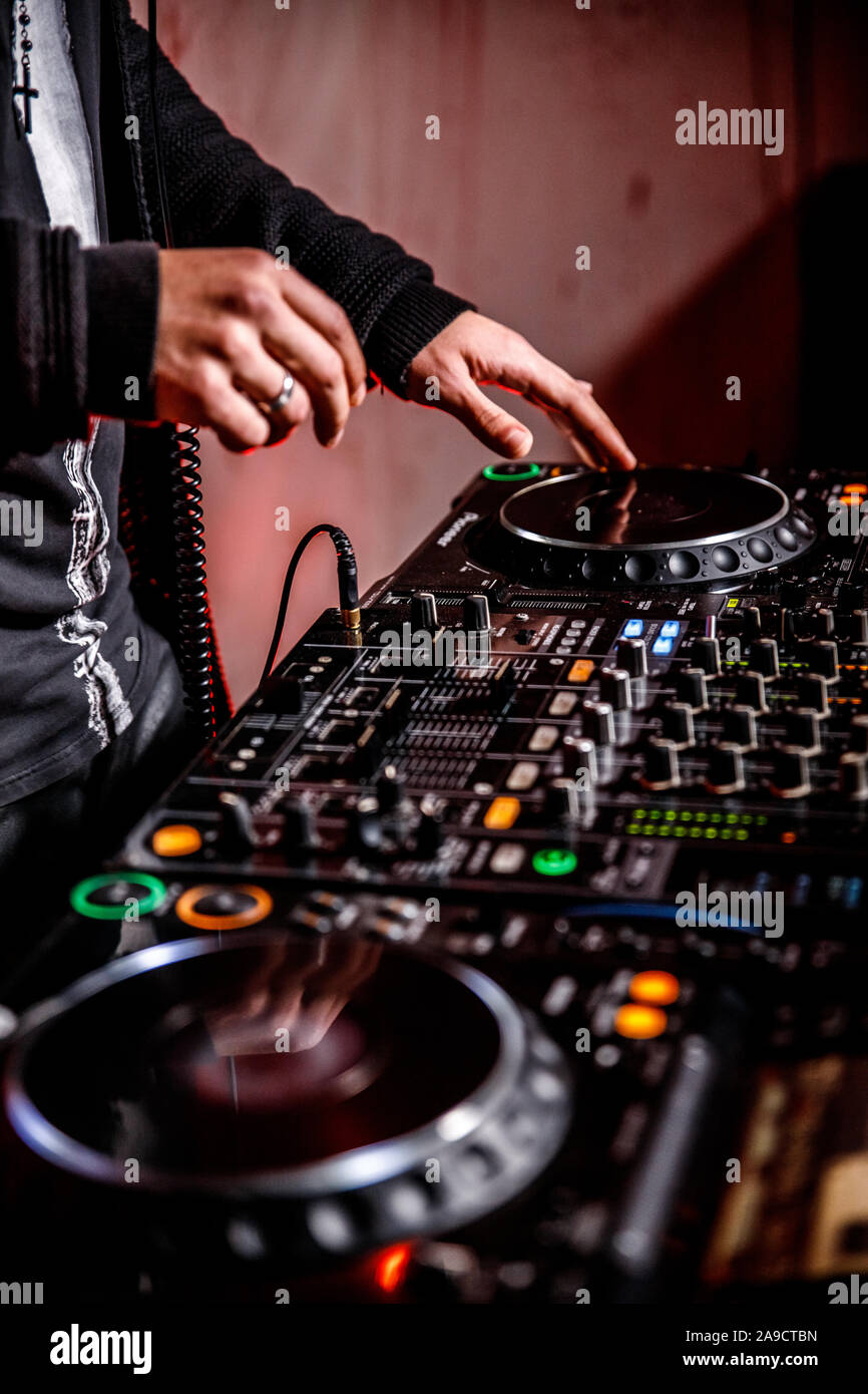 DJ spielt live und Mischen von Musik auf Drehsockel Konsole im Stadium der Night Club. Disk Jokey Hände auf einem Mischpult Station im Club Party. DJ-Mixer Stockfoto