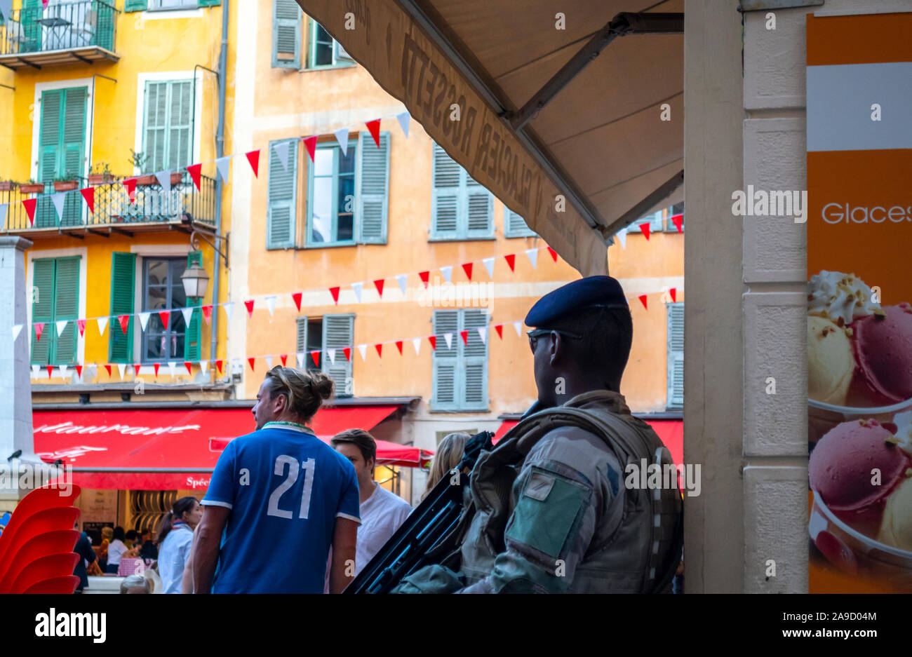 Eine junge schwarze Französische Armee Offizier mit Baskenmütze und automatisches Gewehr wacht im Stadtzentrum von Nizza, Frankreich. Stockfoto