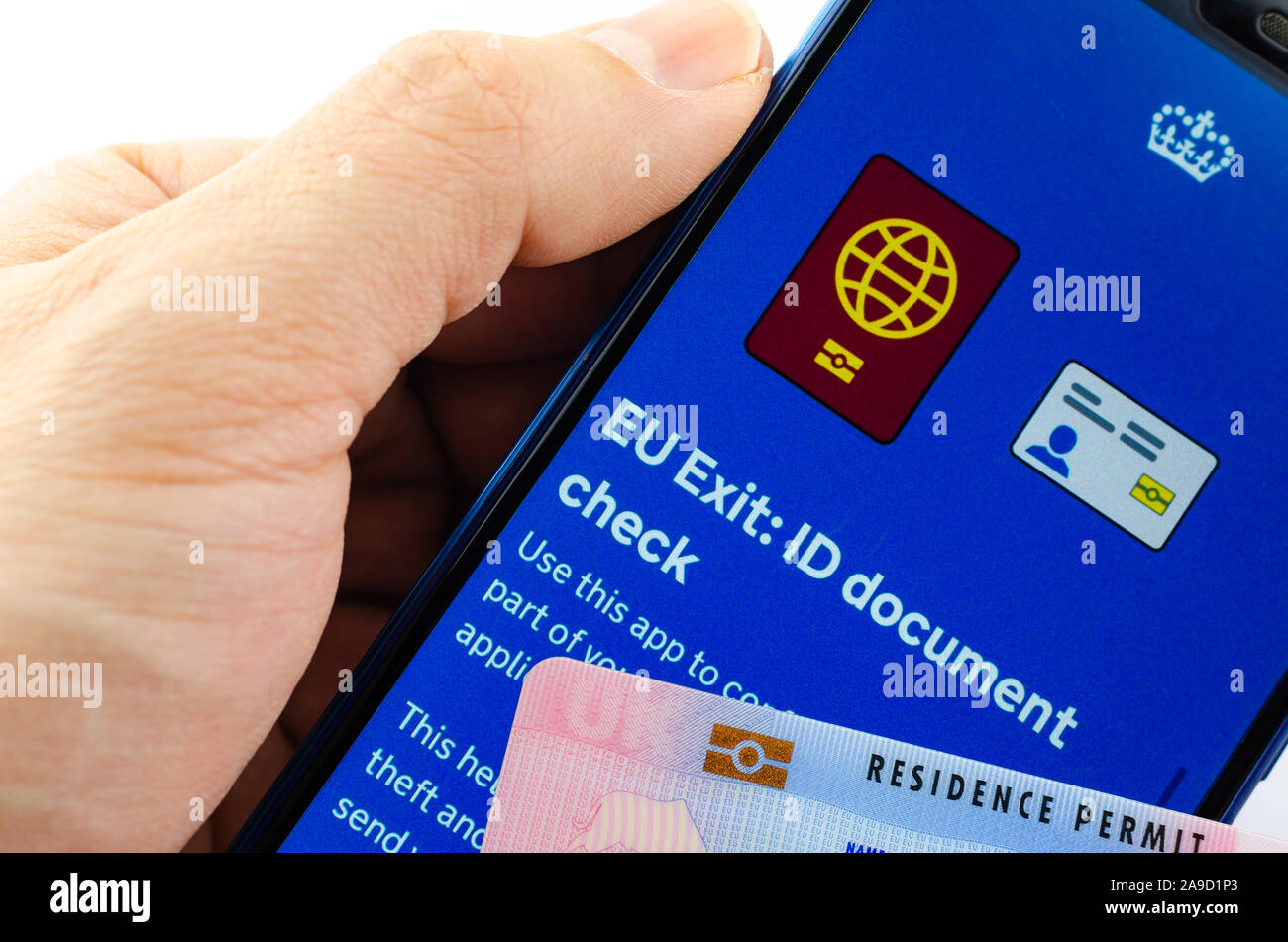 Aufenthaltserlaubnis Card (BRP) neben Großbritannien EU Ausfahrt ID-Dokument prüfen App auf dem Bildschirm des Smartphones halten in der Hand. Stockfoto