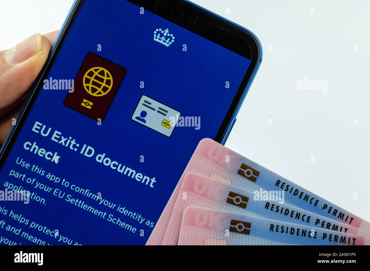 Aufenthaltserlaubnis Karten neben Großbritannien EU Ausfahrt ID-Dokument prüfen App auf dem Bildschirm des Smartphones halten in der Hand. Stockfoto