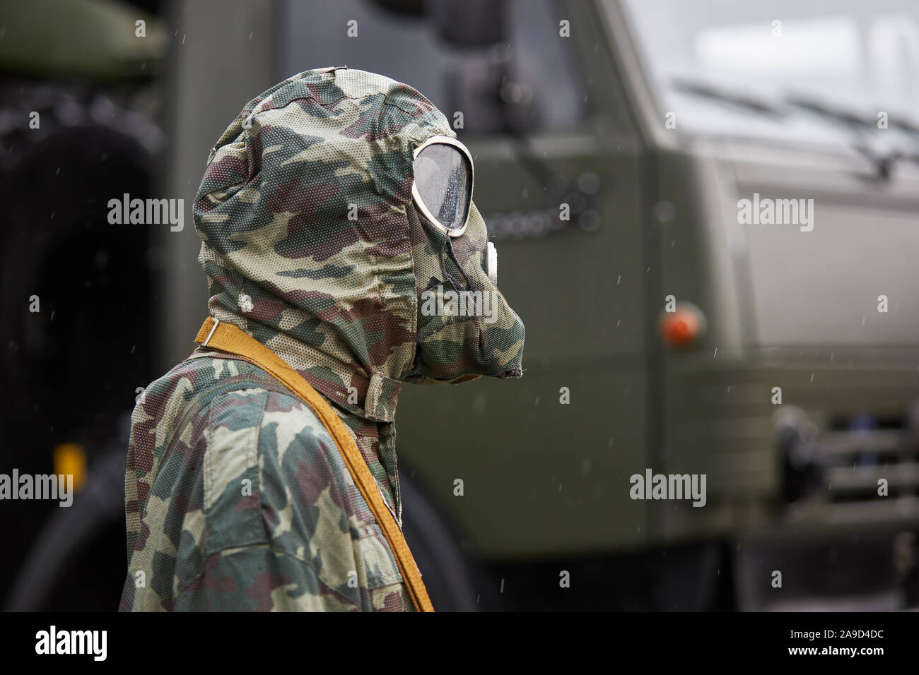 Mannequin gekleidet in einem speziellen Camouflage chemischen Schutzanzug und Gasmaske steht auf dem Hintergrund einer Militär-LKW Stockfoto