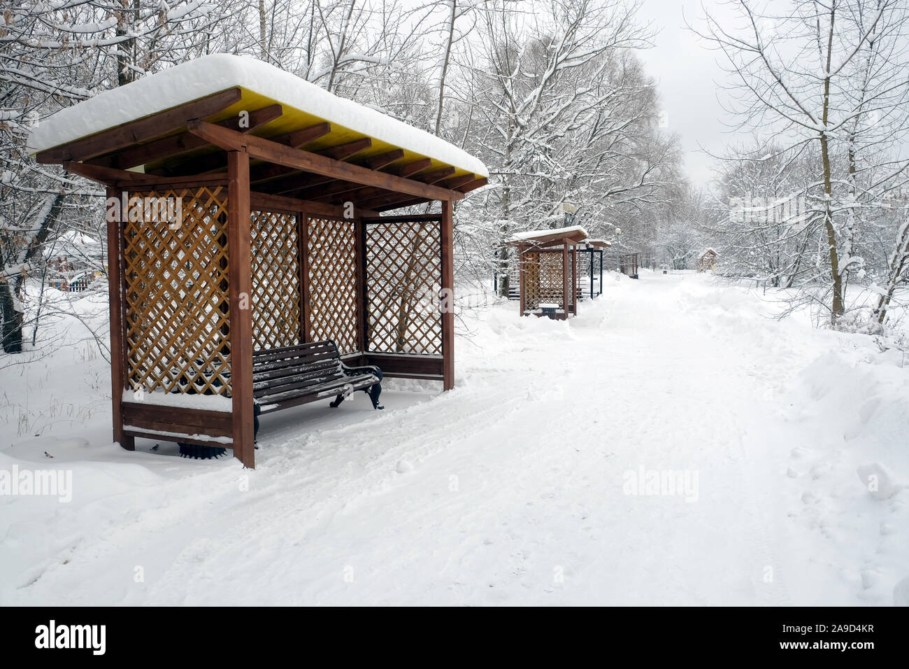 Winterlandschaft mit Laufsteg in den verschneiten Park und die Bänke in den Pavillons für Entspannung perspektivische Ansicht Stockfoto