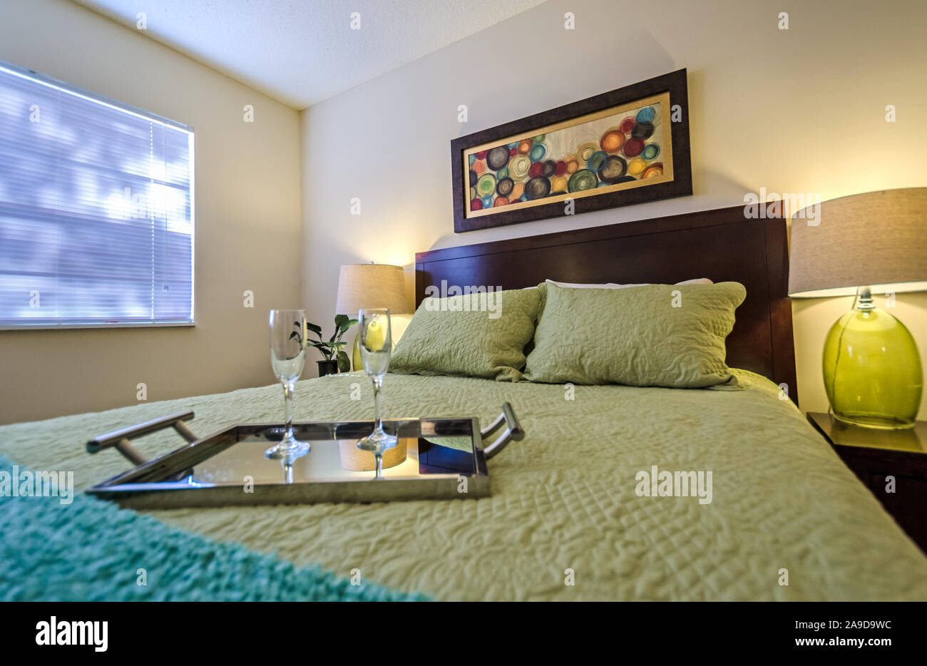 Ein Fach mit champagnergläser sitzt auf einem Bett in einem Schlafzimmer im Herbst Wald Apartments, auf Foreman Road in Mobile, Alabama. Stockfoto