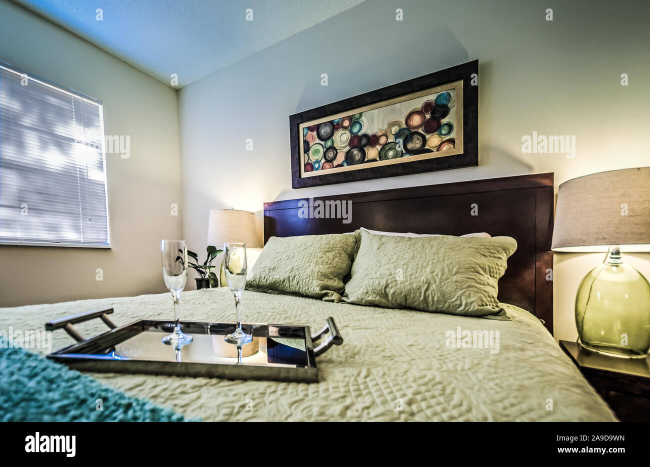 Ein Fach mit champagnergläser sitzt auf einem Bett in einem Schlafzimmer im Herbst Wald Apartments, auf Foreman Road in Mobile, Alabama. Stockfoto
