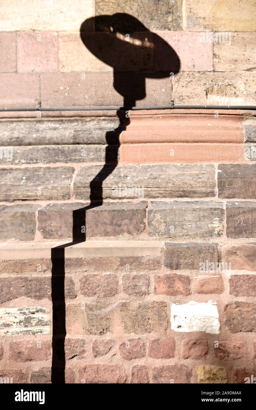 Eine markante Laterne Schatten auf die Wand einer Kirche. Stockfoto