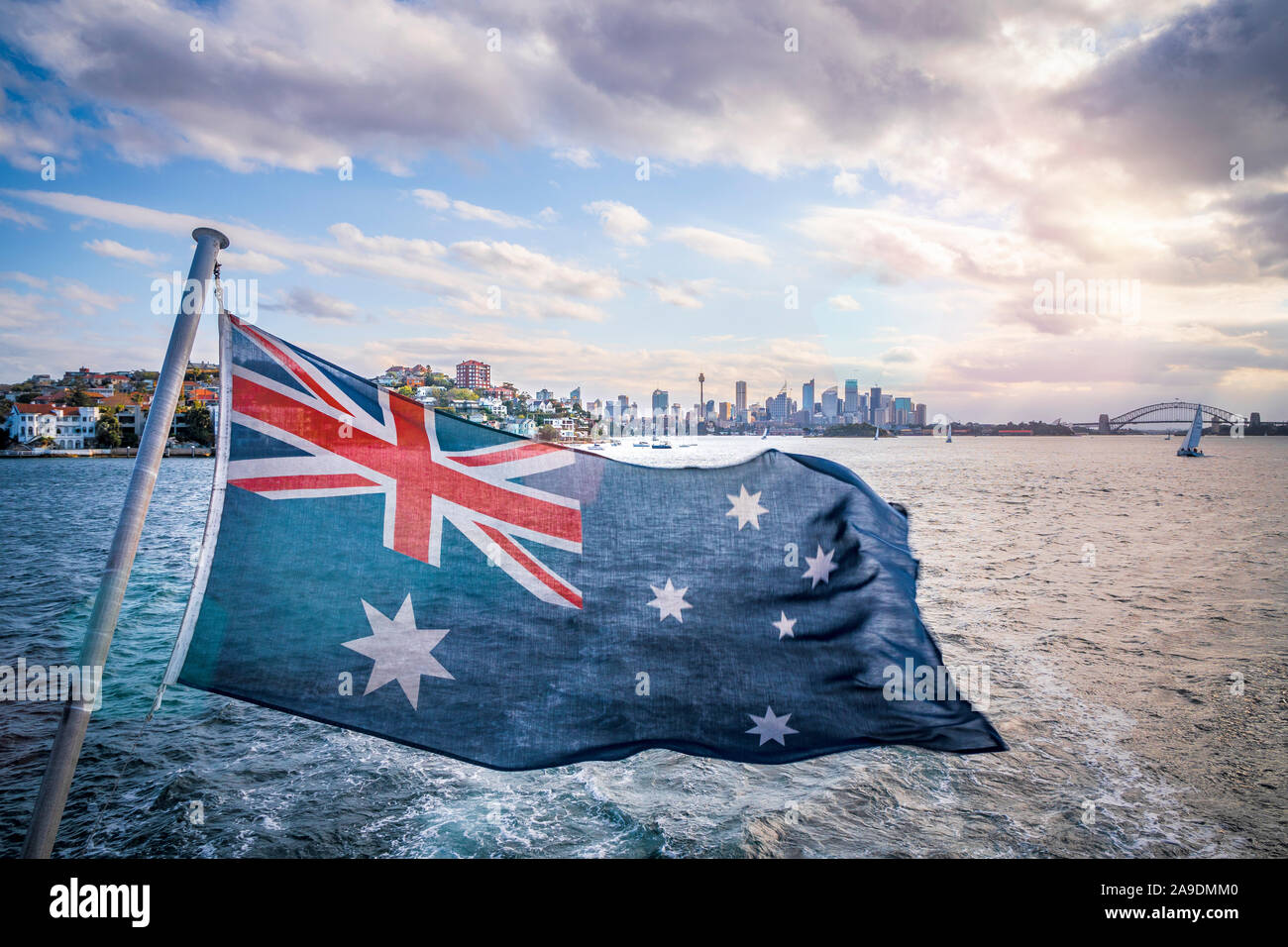 Oper und die Sydney Harbour Bridge von einem Schiff, Australische Flagge im Vordergrund Stockfoto