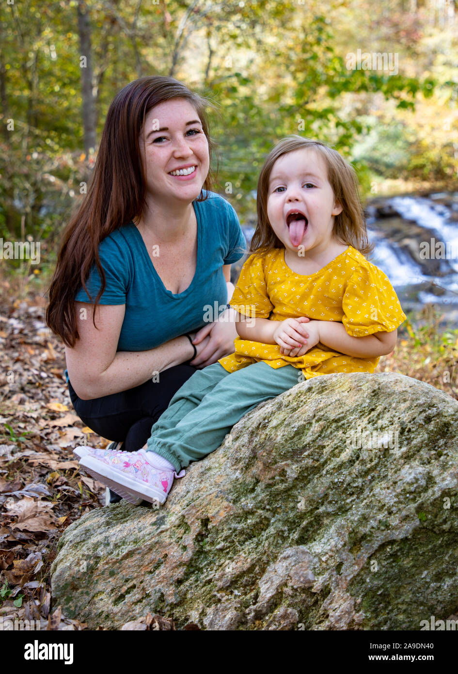 Tochter ragt aus der Zunge, während Mutter lacht Stockfoto
