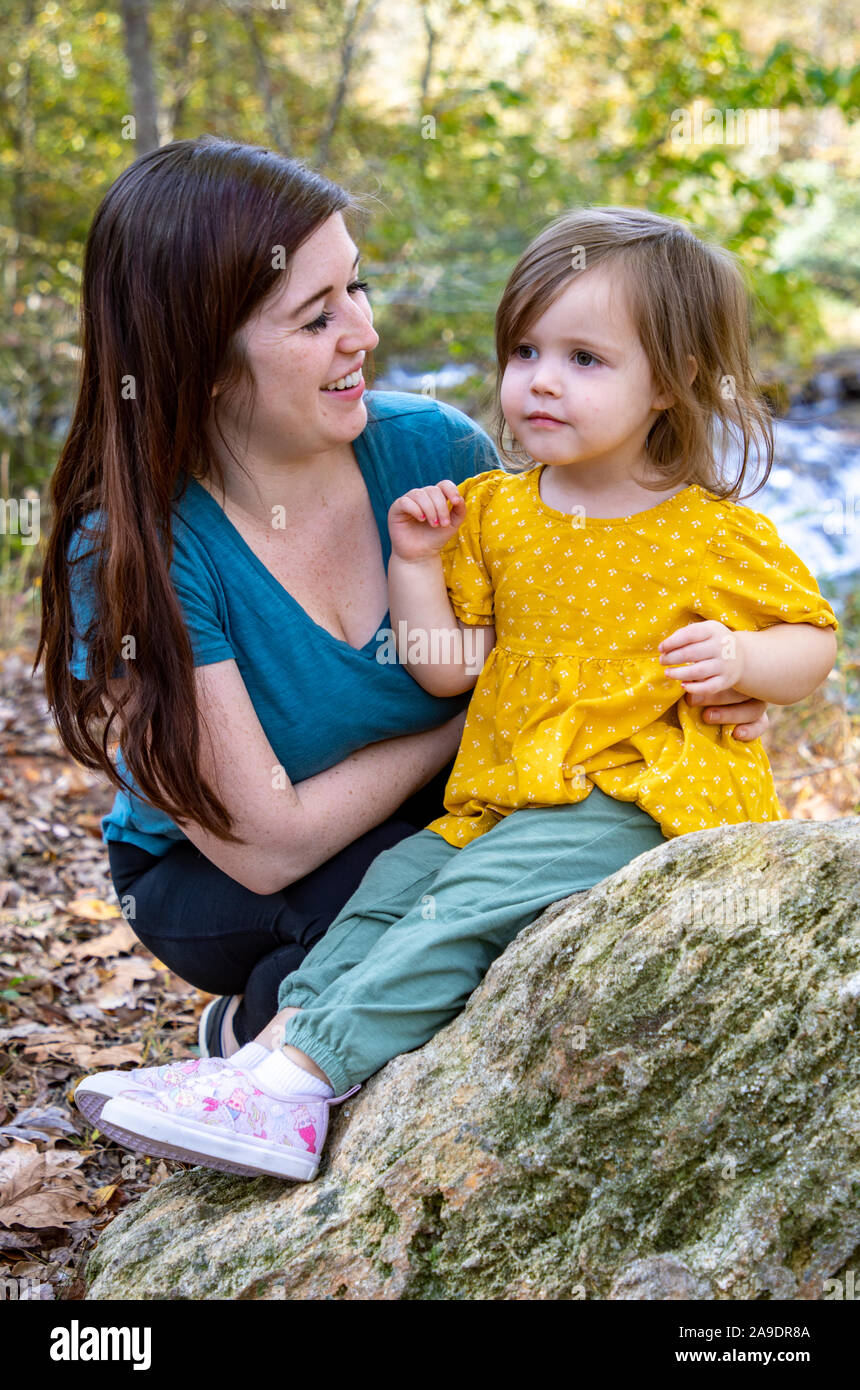 Mutter und Tochter sprechen in der Natur vor dem Wasserfall Stockfoto