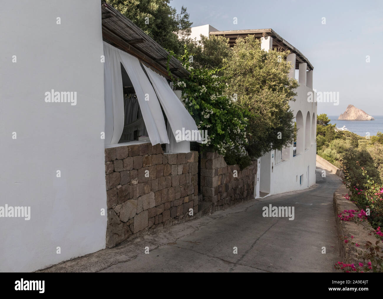 Oslo auf der Insel Panarea, weiße Vorhänge bieten Sonnenschutz, im Hintergrund Lisca Bianca Stockfoto