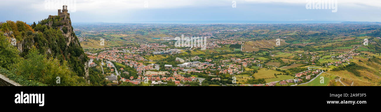 Antenne Panorama der erste Turm von San Marino, Guaita Schloss an der Klippe Rand des Monte Titano mit großen ländlichen Landschaft. San Marino Stockfoto