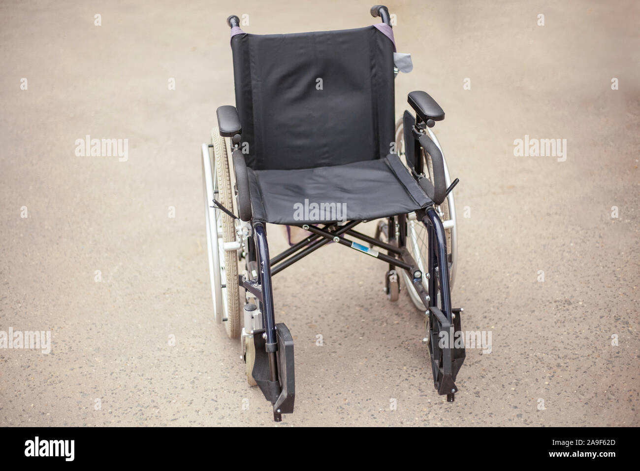 Rollstuhl Rollstuhl auf der Straße. Soziale Hilfe für Menschen mit Verletzungen des Bewegungsapparates. Bequeme Sessel für den Transport von INAKTI Stockfoto