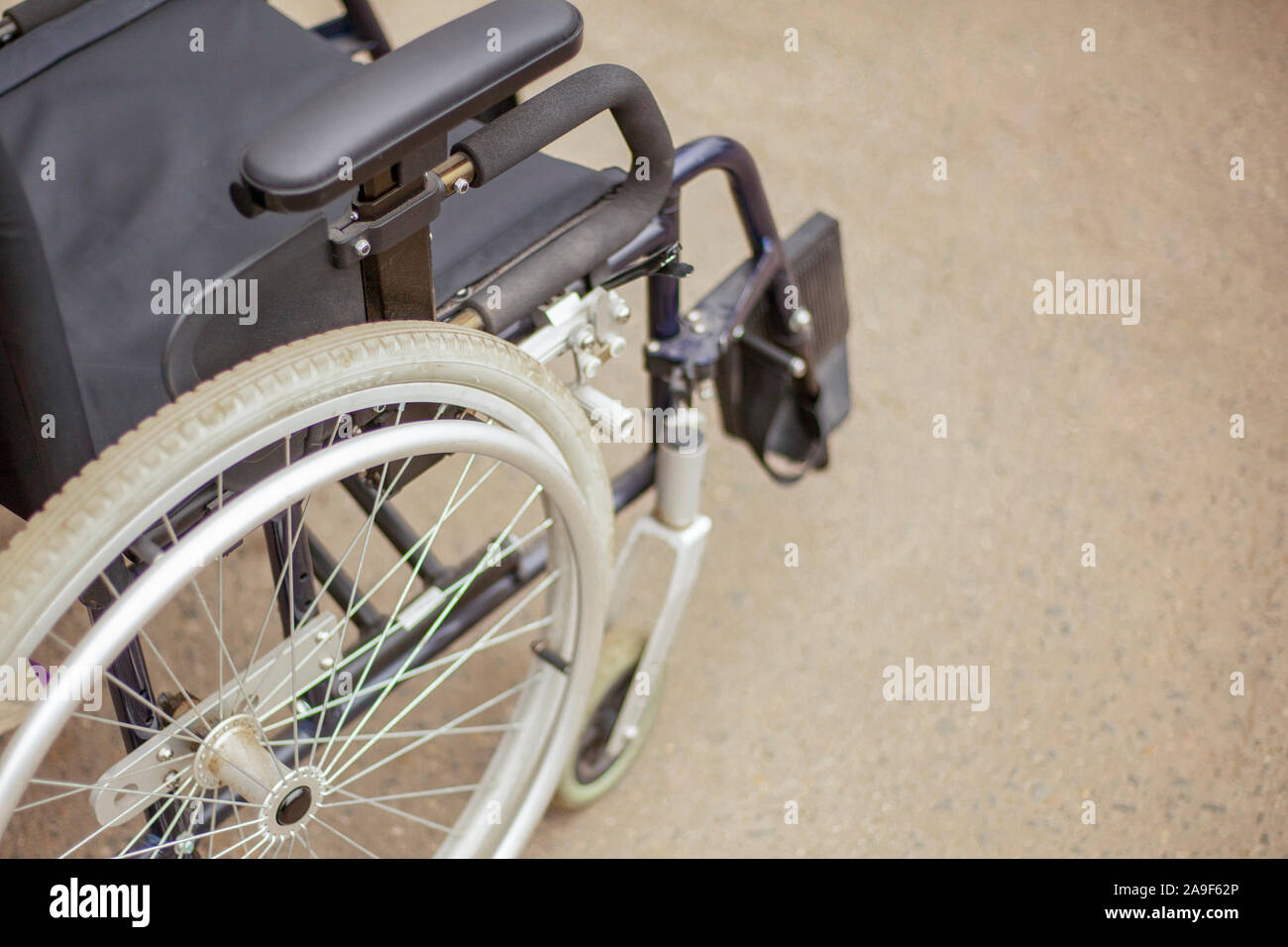 Rollstuhl Rollstuhl auf der Straße. Soziale Hilfe für Menschen mit Verletzungen des Bewegungsapparates. Bequeme Sessel für den Transport von INAKTI Stockfoto