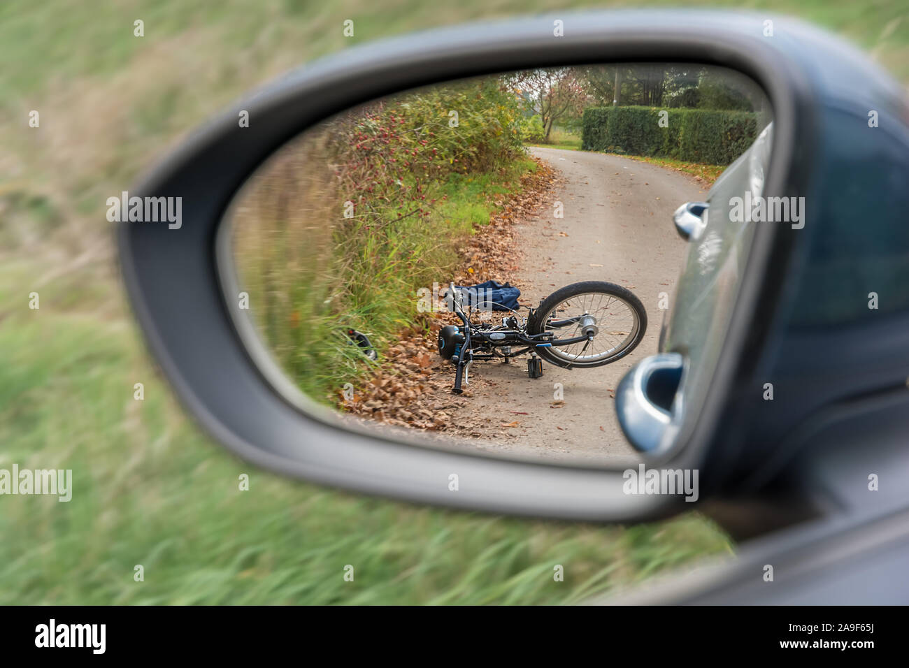 Unfall zwischen einem PKW und einem Radfahrer mit dem Fahrrad in den Rückspiegel dargestellt Stockfoto