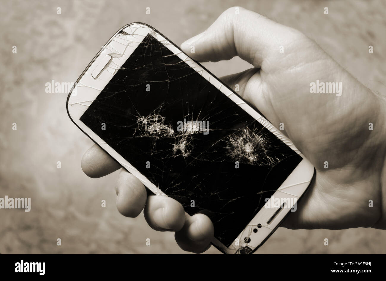 Männliche Hand, die auf einem Smartphone mit der gebrochenen anzeigen. Stockfoto
