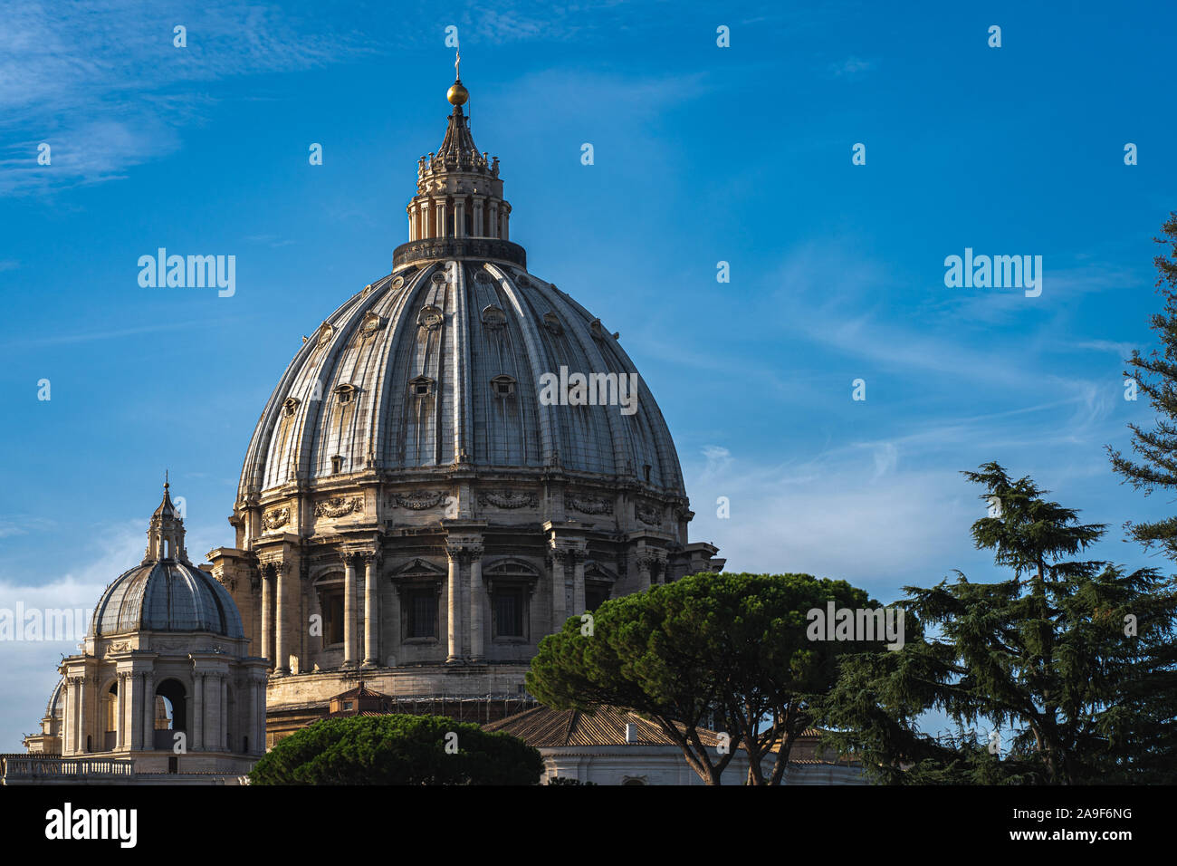 In der Nähe von Petersdom bei sonnigem Wetter. Grüne Bäume, blauer Himmel und Sain Peter Basilika im Vatikan. Stockfoto