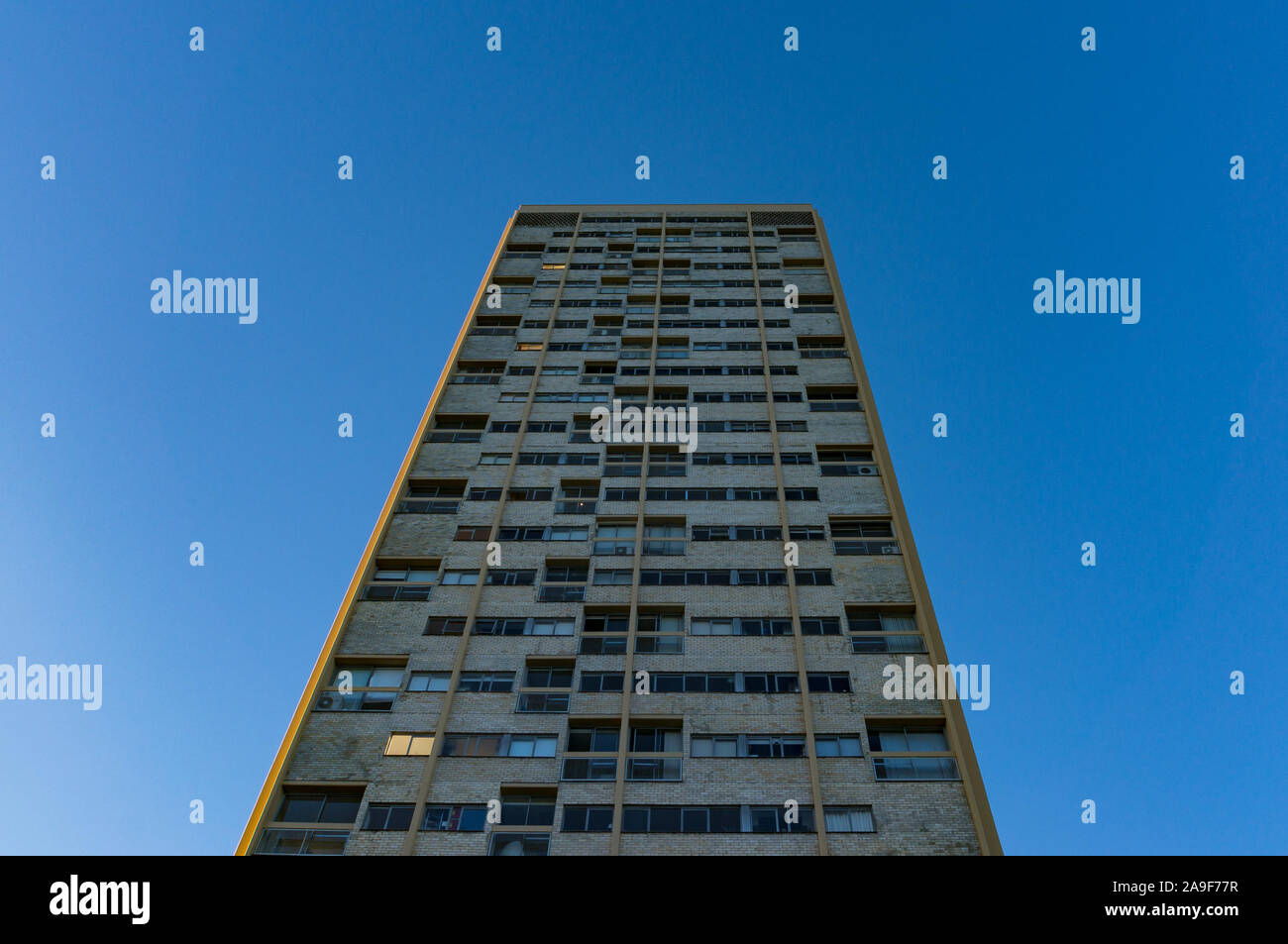 Hohes Gebäude mit Windows gegen den blauen Himmel im Hintergrund. Bedrückend Architektur Design in der Nachkriegszeit im internationalen Stil Stockfoto