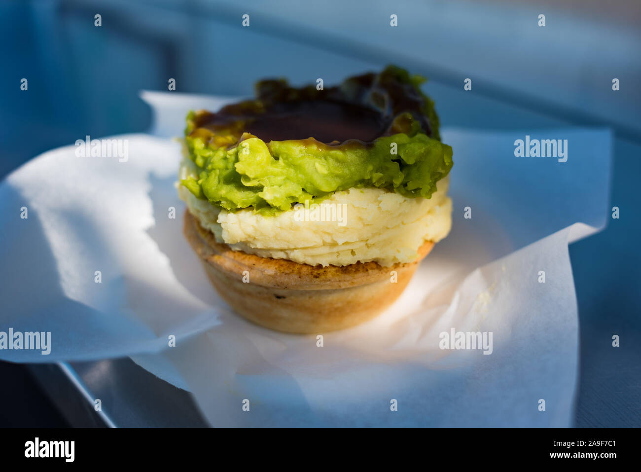 Australische traditionelle Fleisch Torte mit Kartoffelpüree, grüne Erbsen und Soße in Blätterteig Fall Stockfoto