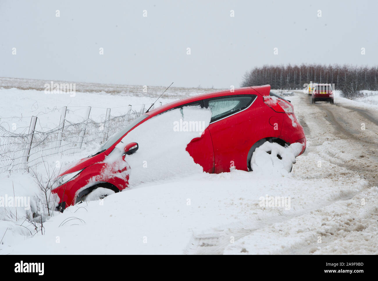 Schnee vom auto entfernen. auto von schneefall reinigen. schnee auf autos  nach schneefall. urbane winterszene. auto mit neuschnee bedeckt. der  prozess der reinigung des autos von schnee