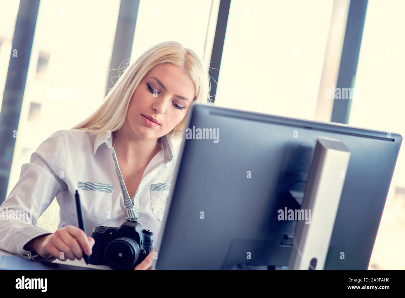 Professionelle Fotografen in ihrem Büro Schreibtisch sitzen und Lächeln. Stockfoto