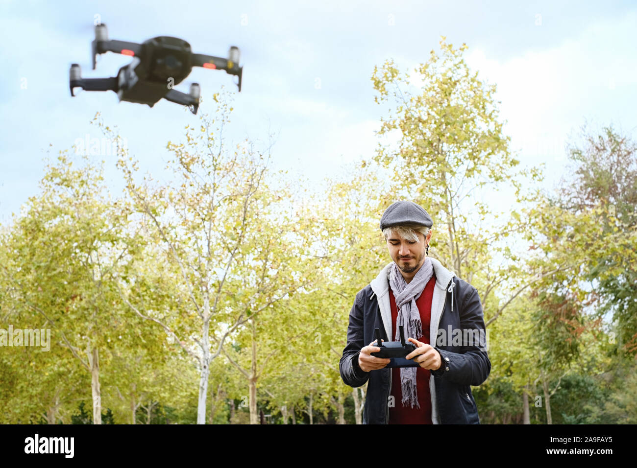 Junger Mann mit Fernbedienung Lernen zu fliegen Quadcopter Drone Stockfoto