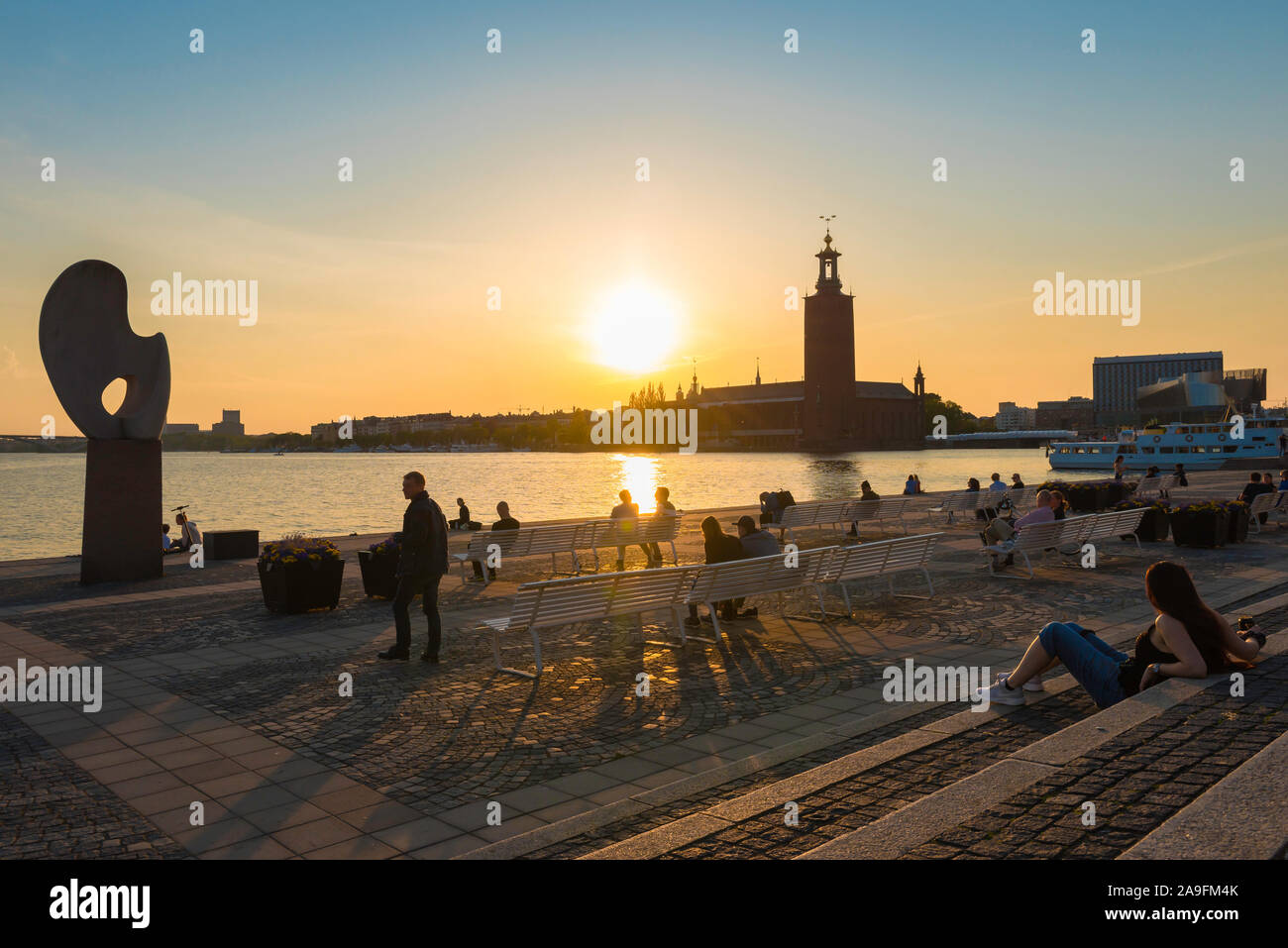 Riddarholmen, Blick auf die Menschen im Sommer entspannen Sie auf der Terrasse am Wasser von riddarholmen beobachten die Sonne über Kungsholmen, Stockholm. Stockfoto