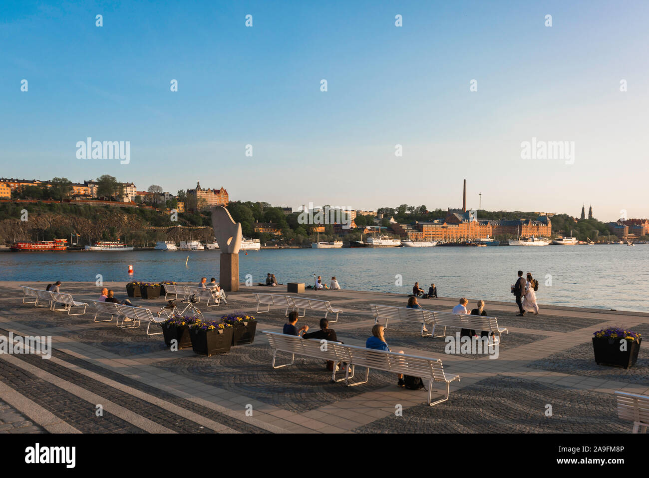 Riddarholmen Stockholm, Sommer Blick von Menschen entspannend auf Bänken auf der Esplanade des Riddarholmen Insel mit Blick auf Södermalm, Stockholm. Stockfoto