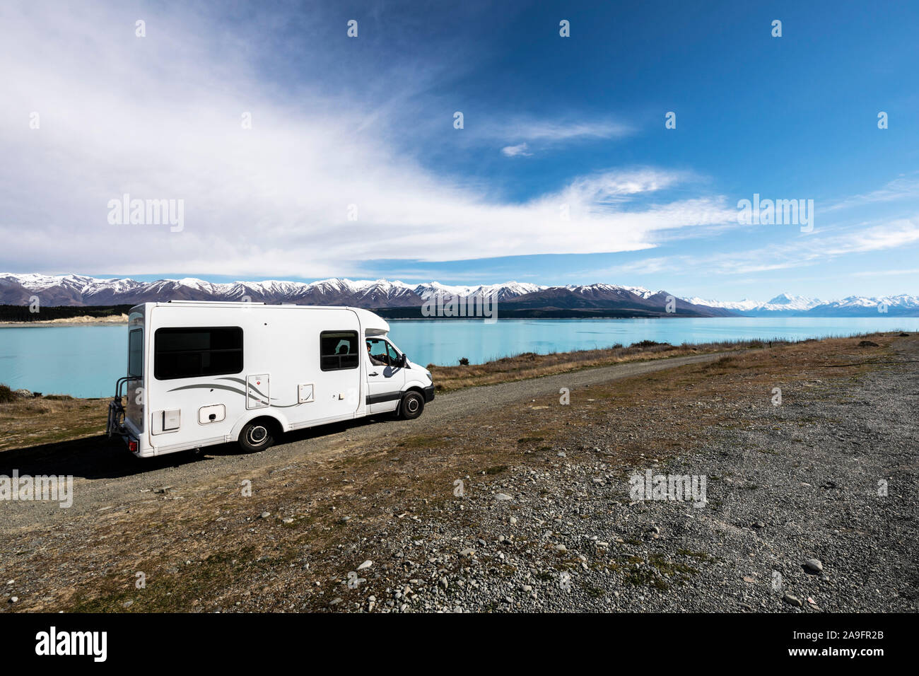 Reisemobil in Feldweg mit blauen See und Schnee caped Berge Stockfoto