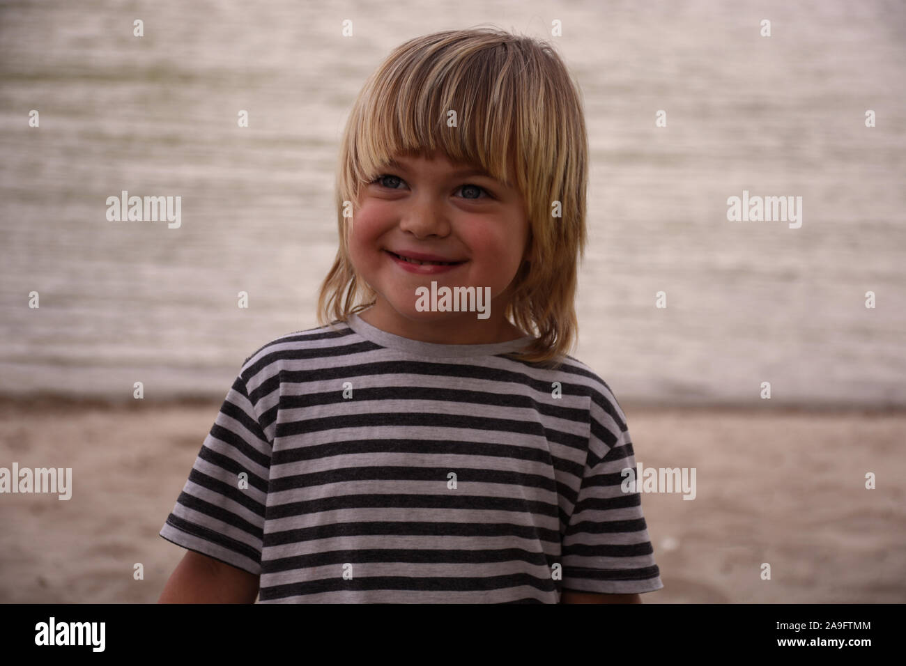 Schönes Portrait eines lächelnden blonde Junge am Strand Stockfoto