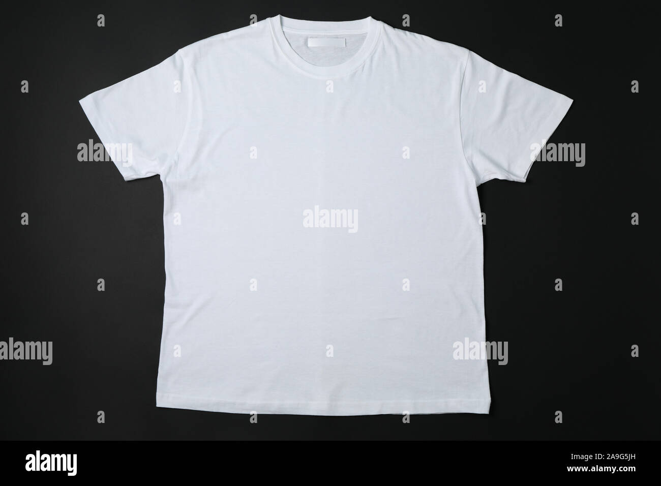 Leeres weißes T-Shirt mit schwarzem Hintergrund, Platz für Text Stockfoto