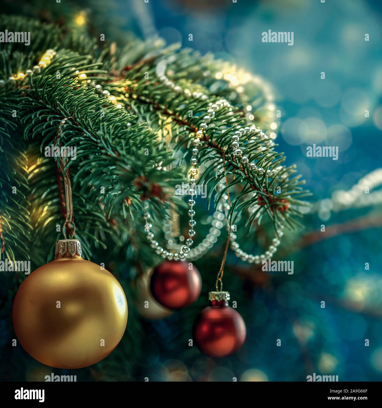 Christbaumschmuck in hell schimmernde und glänzende Farben mit  Weihnachtsbeleuchtung mit unscharfen snowy Hintergrund Stockfotografie -  Alamy