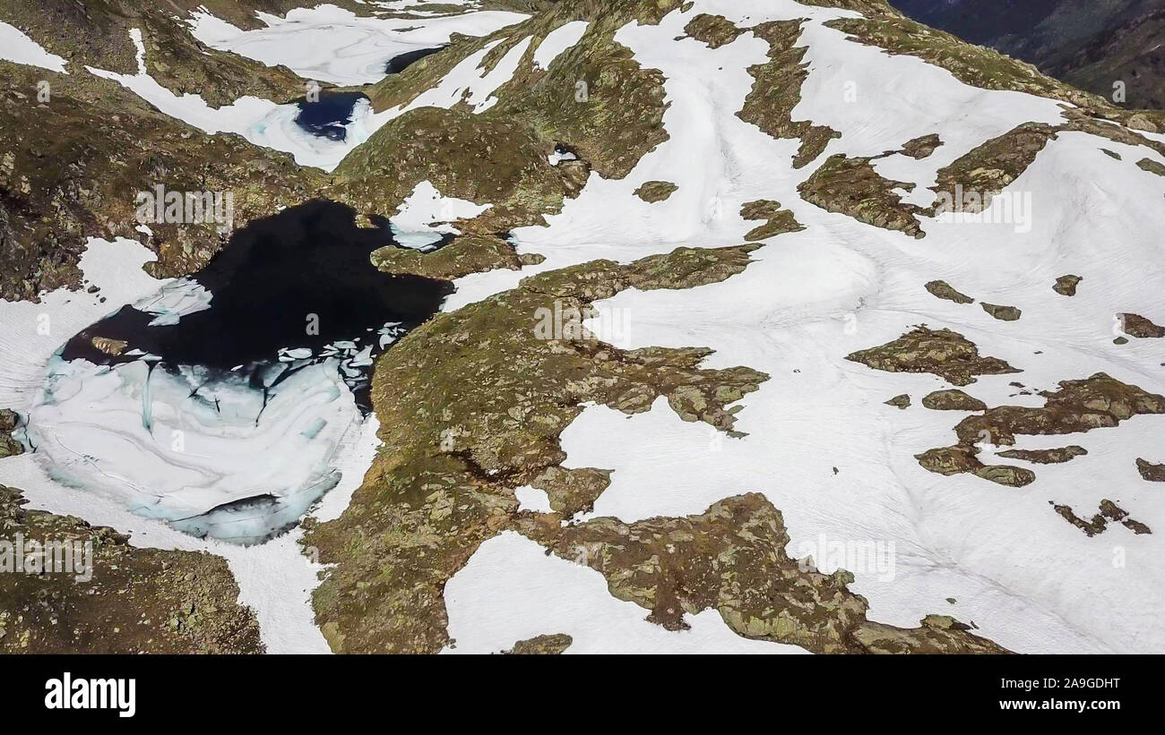 Von oben nach unten Blick auf Schladming Alpen, teilweise noch mit Schnee bedeckt. Der Frühling langsam erreichen die höchsten Teile des Gebirges. Es gibt einen See in t Stockfoto