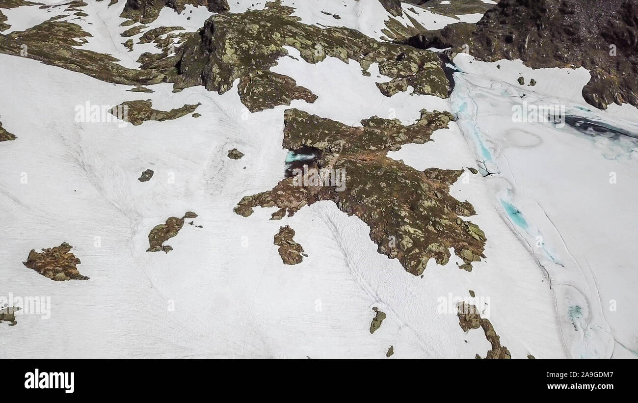 Top down Sicht auf einem zugefrorenen See in Schladming Alpen, teilweise noch mit Schnee bedeckt. Der Frühling langsam erreichen die höchsten Teile des Gebirges. Lose Stockfoto