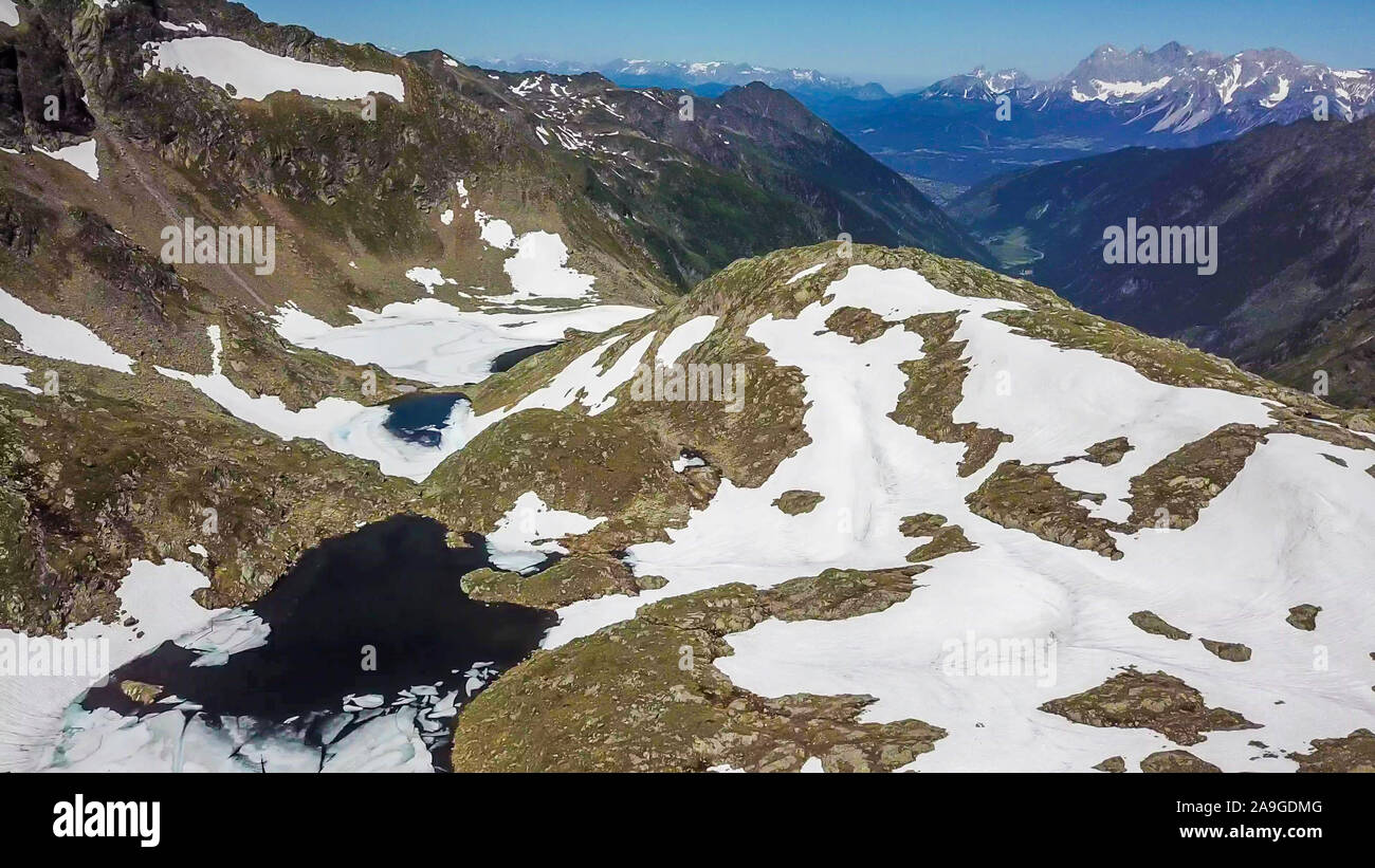Top down Sicht auf einem zugefrorenen See in Schladming Alpen, teilweise noch mit Schnee bedeckt. Der Frühling langsam erreichen die höchsten Teile des Gebirges. Lose Stockfoto