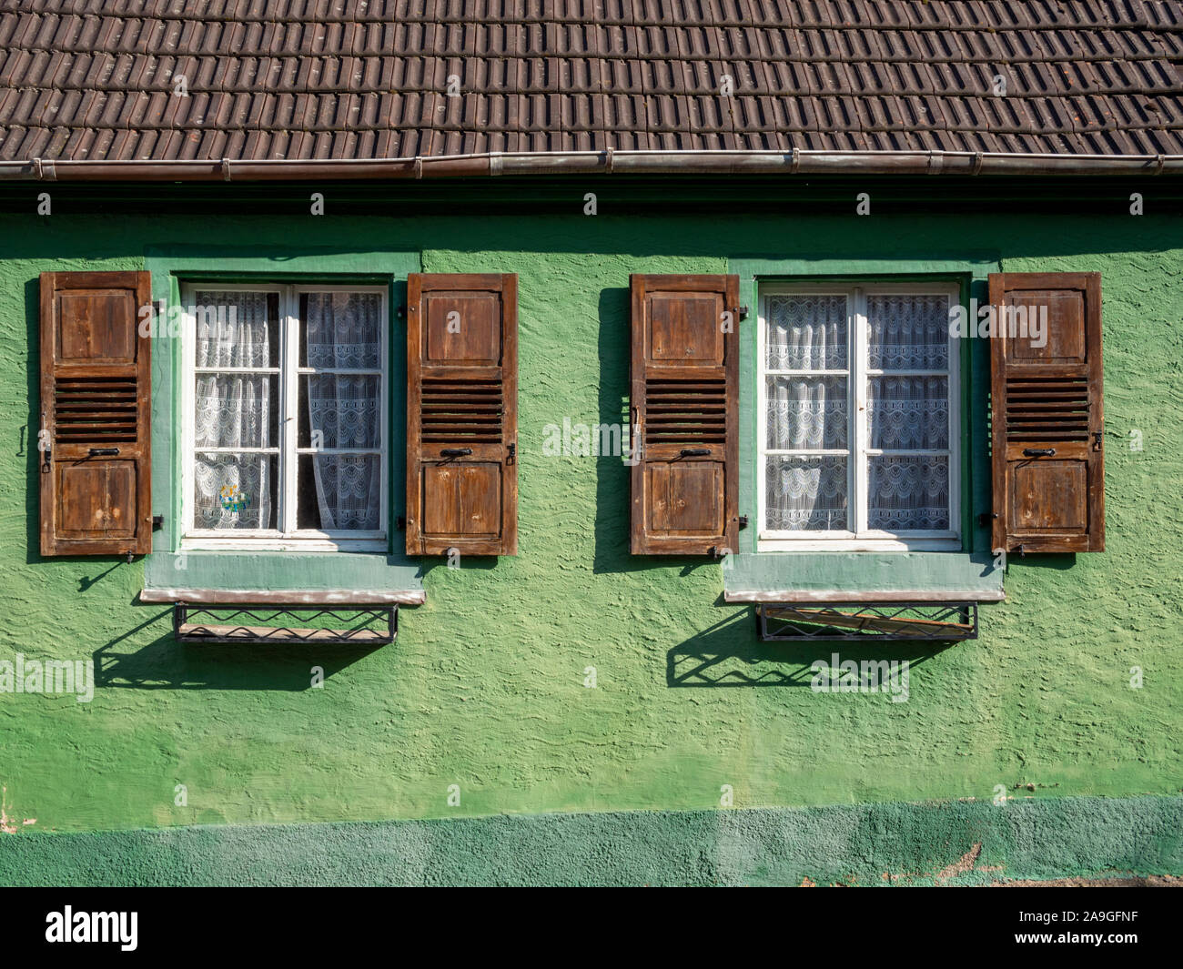 Ein grünes Haus mit hölzernen Fensterläden Stockfoto