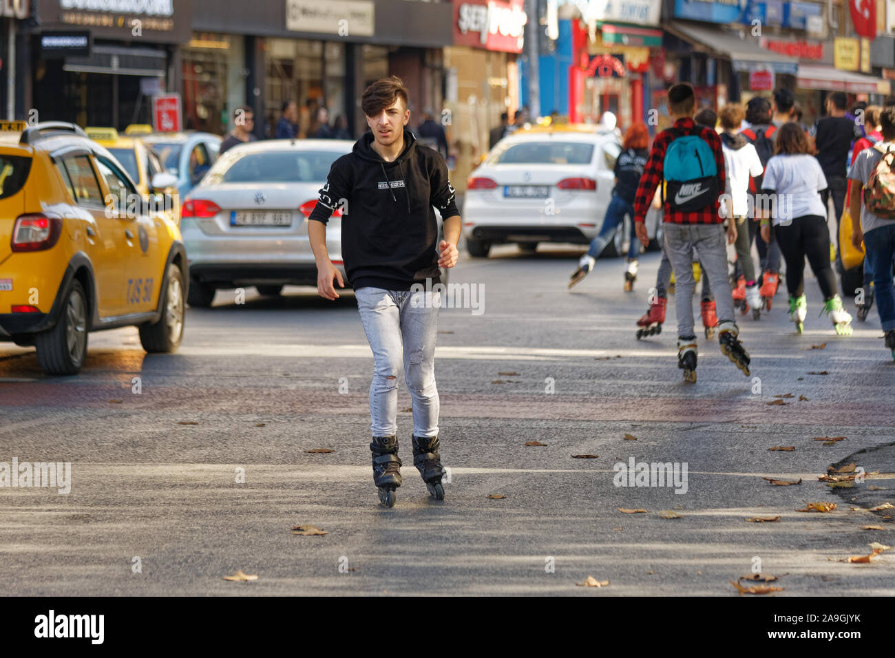 Junger Mann Rolle rückwärts Skaten und seine Begleiter auf der Straße. Stockfoto