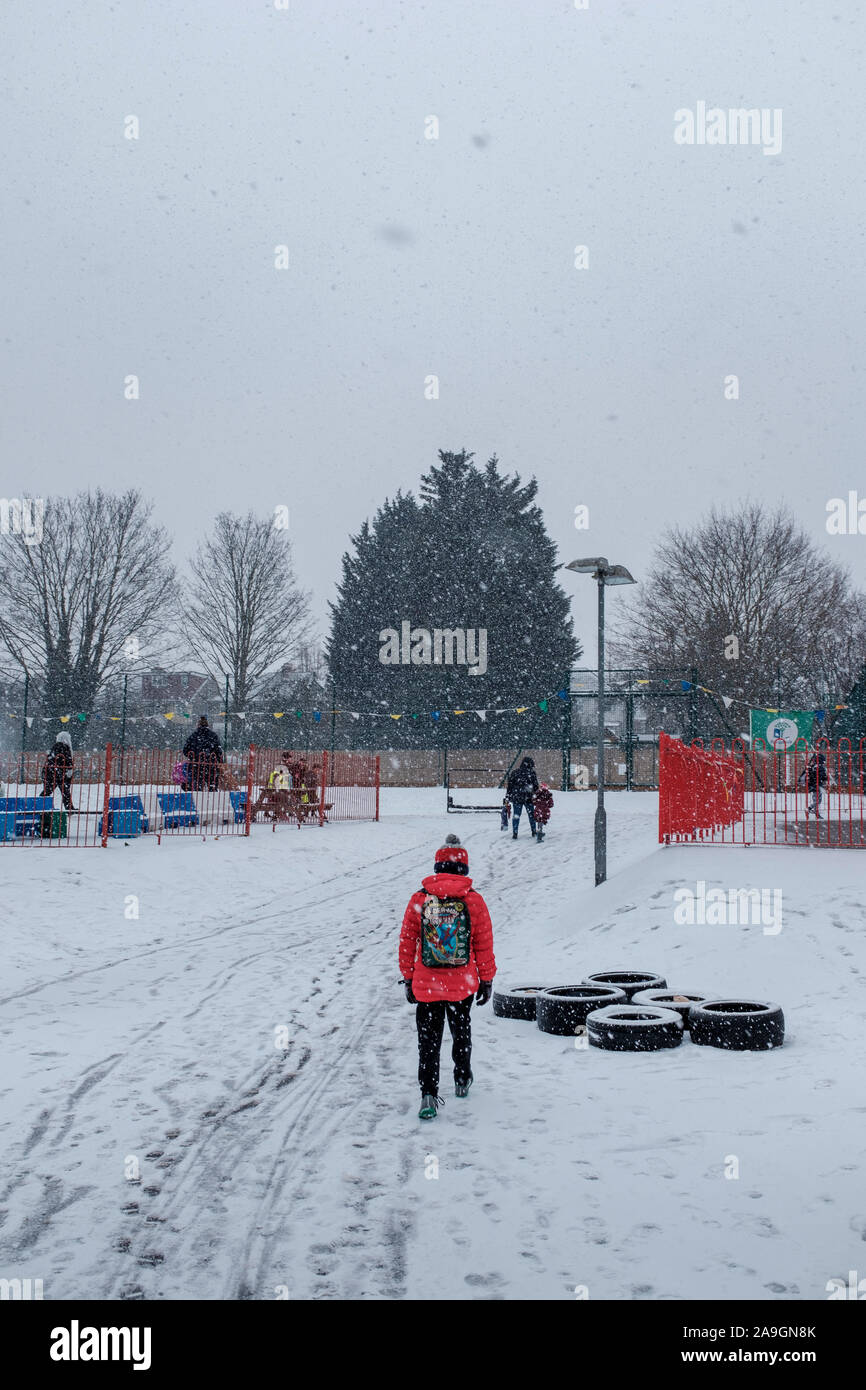 Cheam, Surrey, UK, Grundschule Kinder zu Fuß zur Schule im Schnee Stockfoto