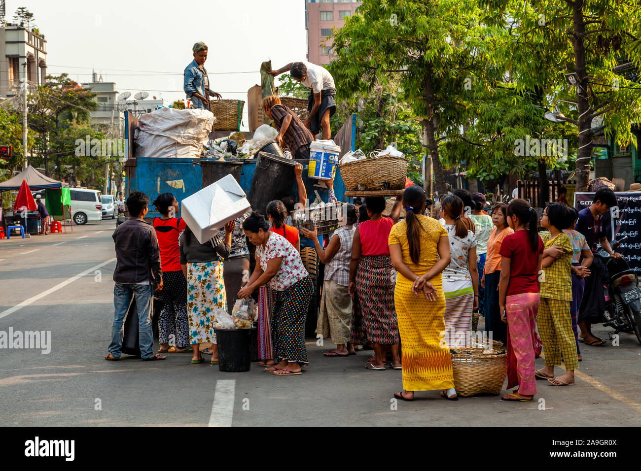 Die lokale Bevölkerung Pass, ihren Abfall/Müll auf eine Garbage Collection Lkw, Mandalay, Myanmar. Stockfoto
