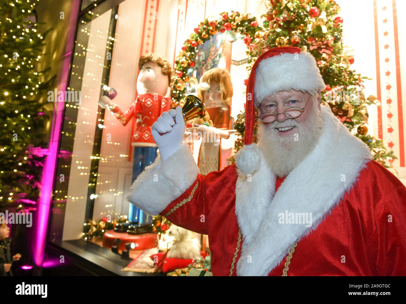 Berlin, Deutschland. 15 Nov, 2019. Ein Weihnachtsmann steht vor dem KaDeWe Weihnachten Fenster Galerie und eine Glocke schellt. Die Kampagne konzentriert sich auf das Leben - Größe Nussknacker, jeder erzählt eine persönliche Weihnachtsgeschichte. Foto: Jens Kalaene/dpa/Alamy leben Nachrichten Stockfoto