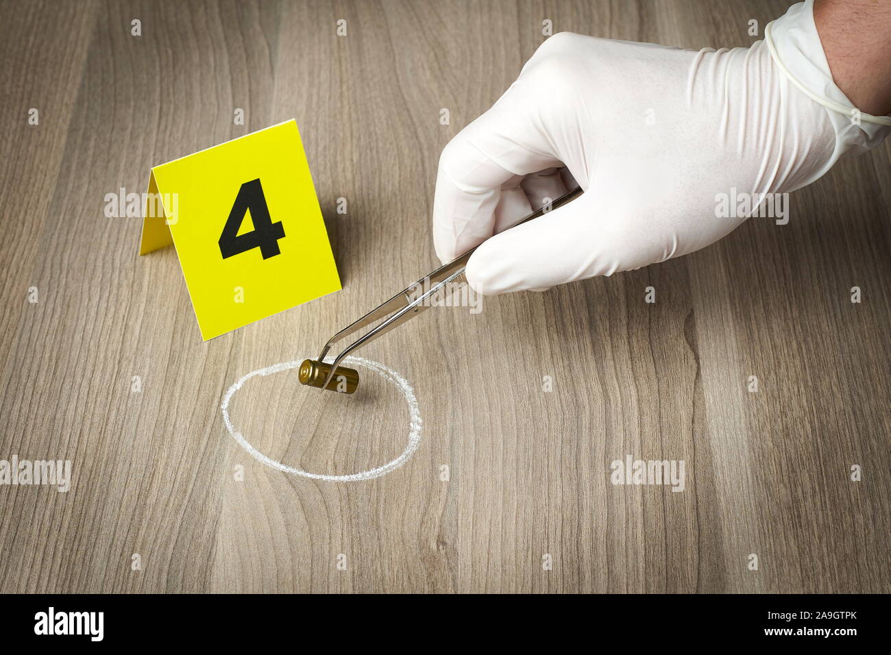 Forensic officer Sammeln einer bullet Gehäuse als Beweisstück Stockfoto