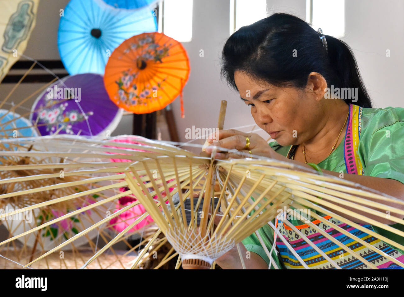 Thailändische Frau, handgeschöpftem Papier Sonnenschirme am Bo Sang weiter nach Chiang Mai, Thailand Stockfoto